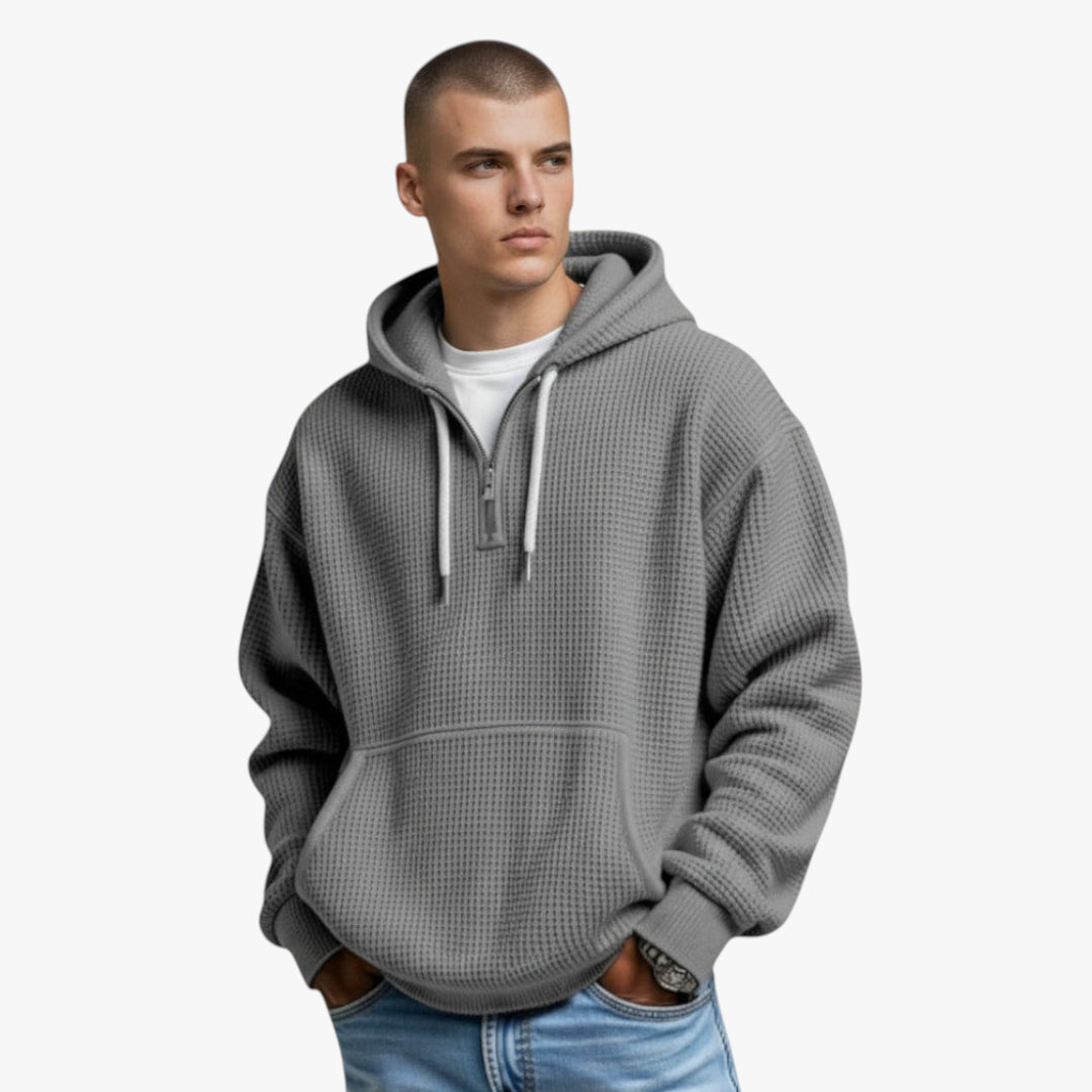 Man wearing a gray pullover with a hood on a white background