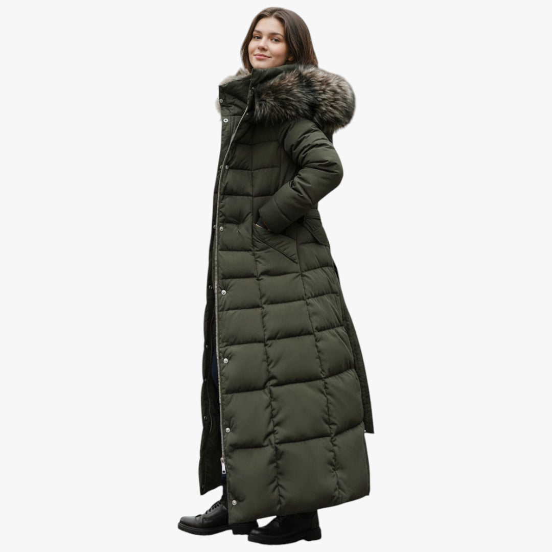Woman wearing a long green puffer coat with a fur-lined hood on a white background