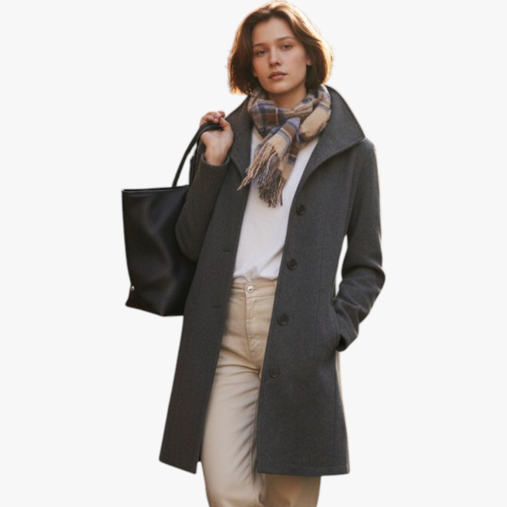 Woman wearing a gray coat with a black bag and plaid scarf on a white background