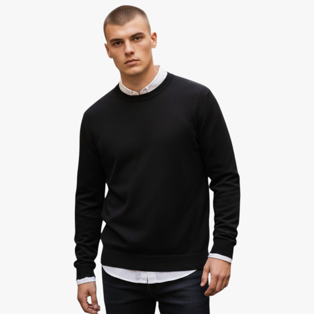 Man wearing a black sweater over a white shirt on a white background
