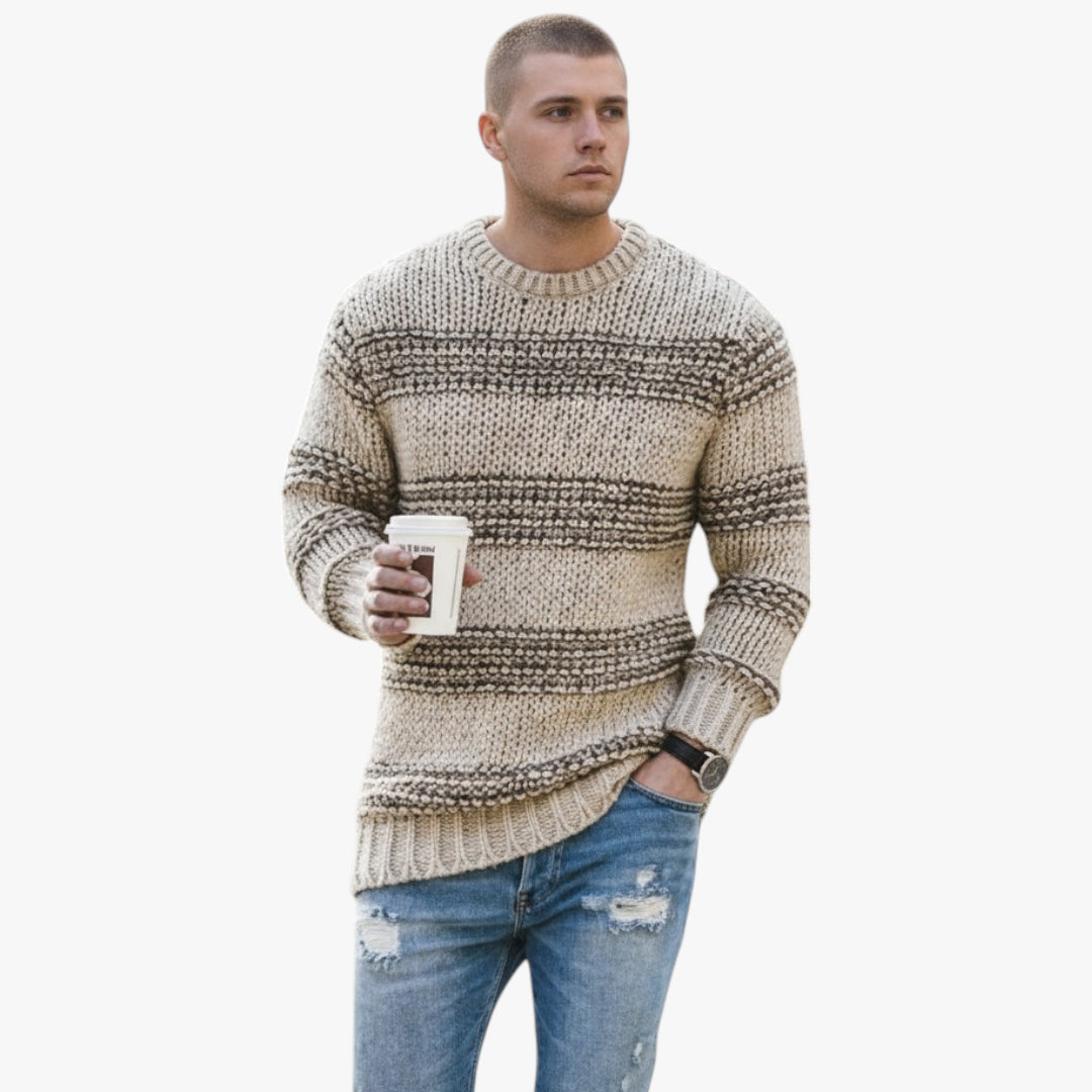 Man wearing a patterned sweater and jeans holding a coffee cup on a white background