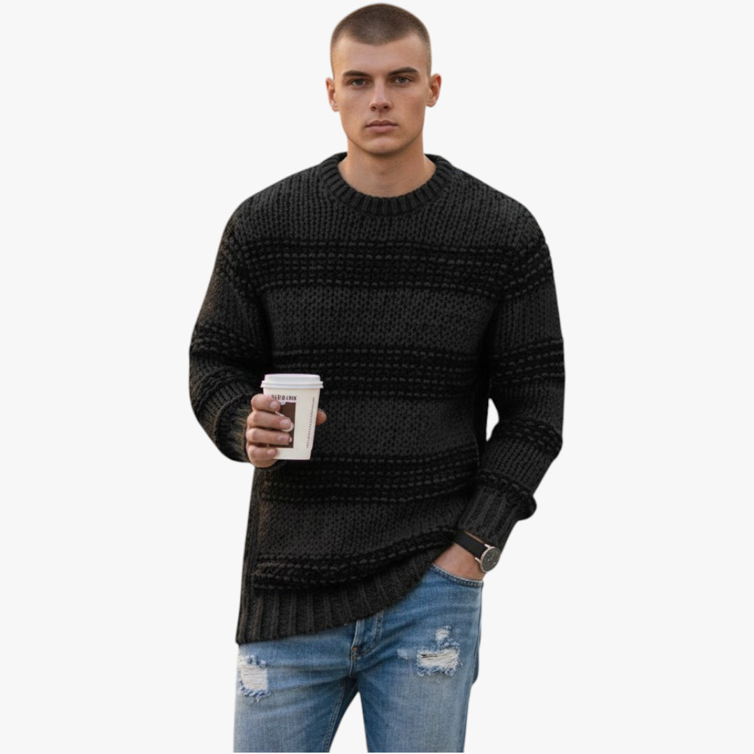 Man wearing a black knitted sweater holding a coffee cup on a white background