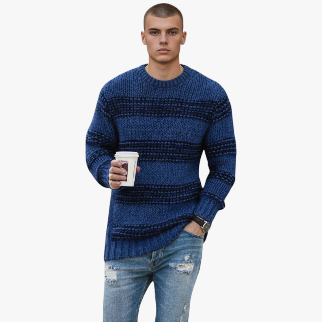 Man wearing a blue patterned sweater holding a coffee cup on a white background