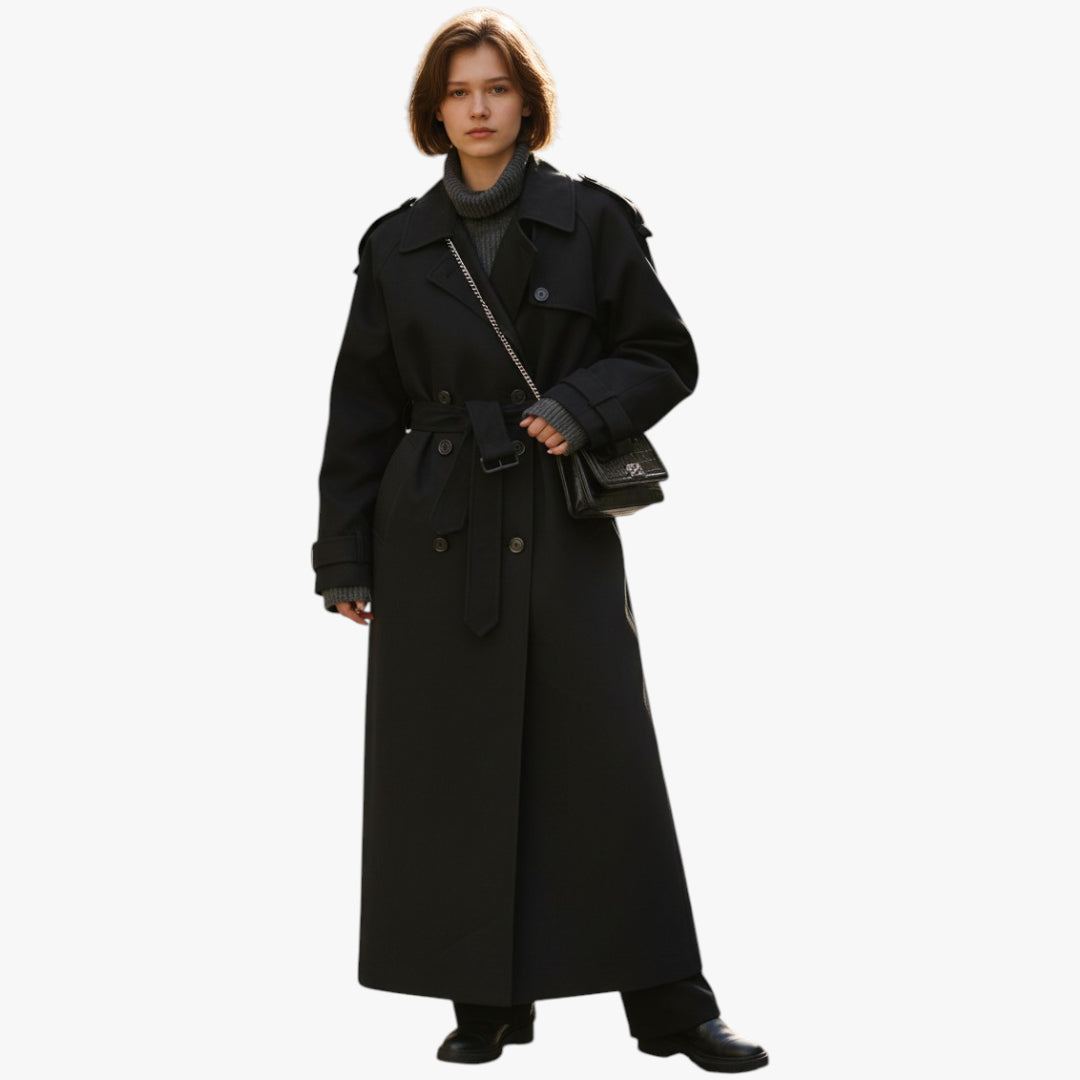 Person wearing a long black coat on a white background