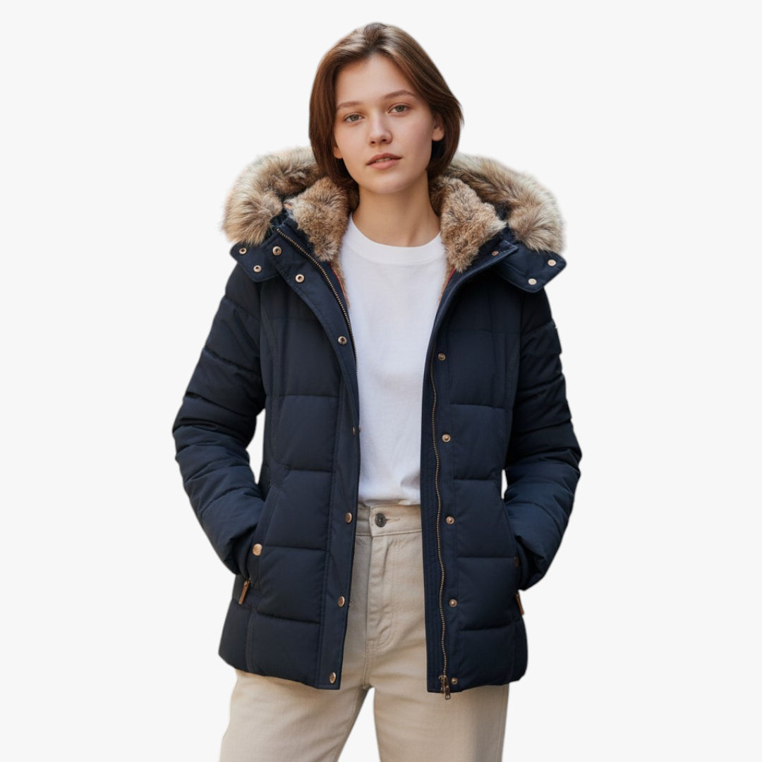 Woman wearing a navy blue puffer jacket with fur hood on a white background