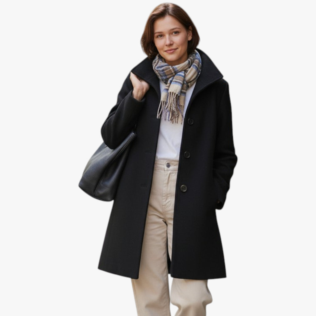 Woman wearing a black coat, beige pants, and a patterned scarf on a white background