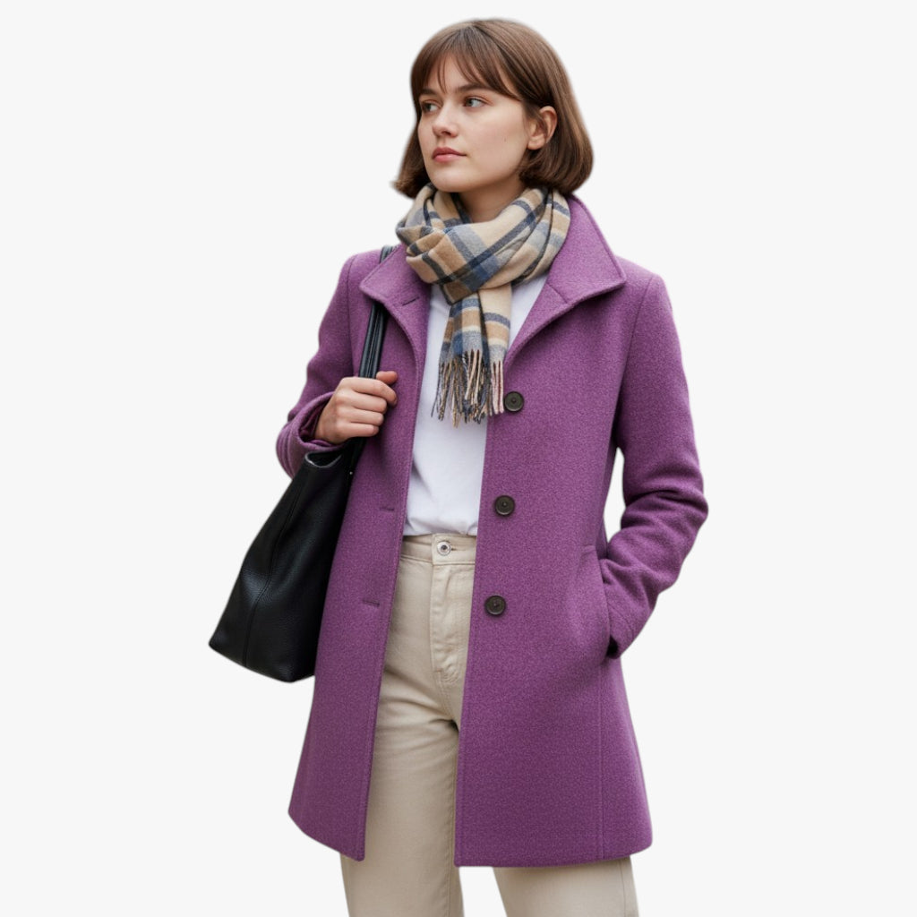 Woman wearing a purple coat with a plaid scarf and holding a black bag on a white background