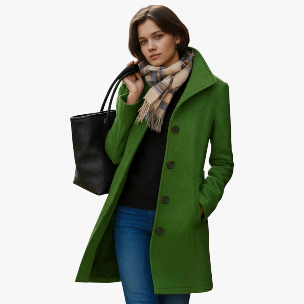 Woman wearing a green coat with a black bag and plaid scarf on a white background